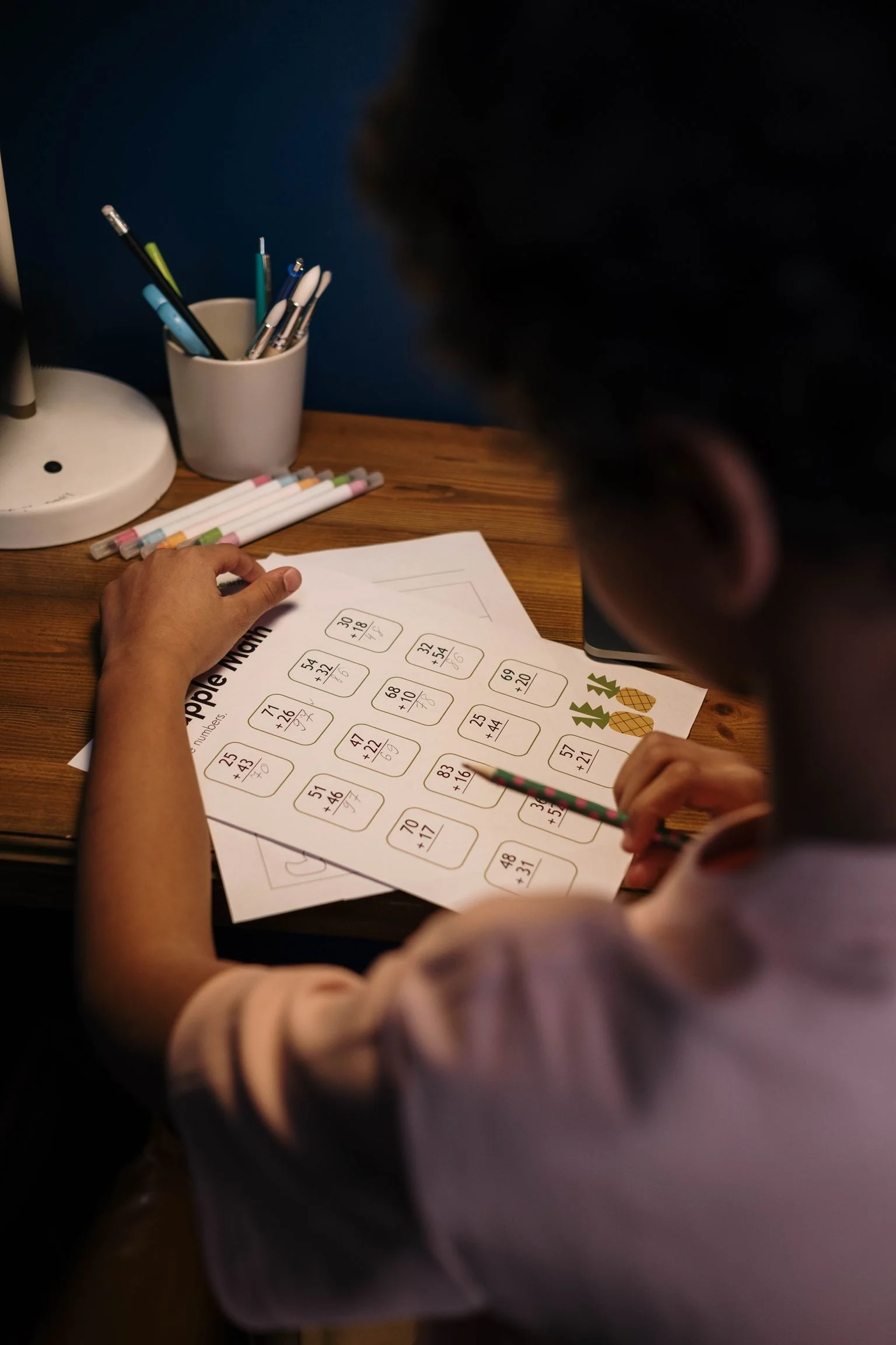 A primary pupil working through Maths with a tutor